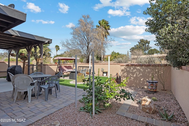 view of patio with a gazebo, outdoor dining space, and a fenced backyard