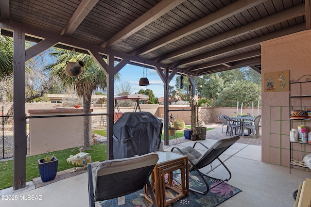 view of patio with fence, grilling area, and outdoor dining space