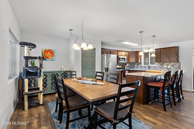 dining room featuring dark wood-style flooring and baseboards