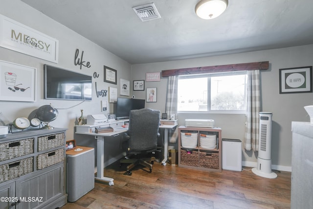 home office featuring wood finished floors, visible vents, and baseboards