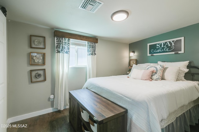 bedroom featuring dark wood finished floors, visible vents, and baseboards