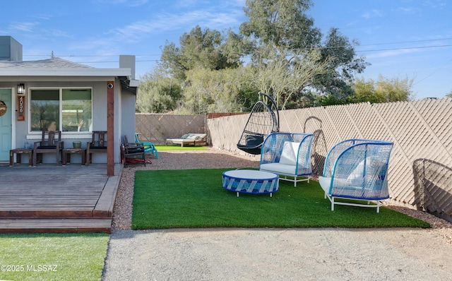 view of yard with a trampoline and a fenced backyard