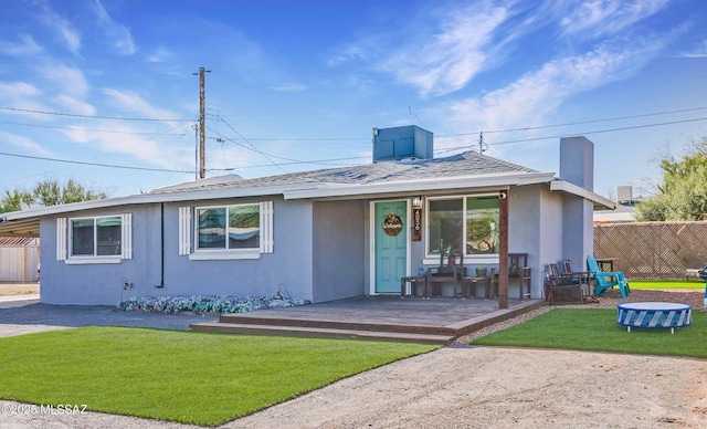 single story home featuring a shingled roof, fence, a front lawn, and stucco siding