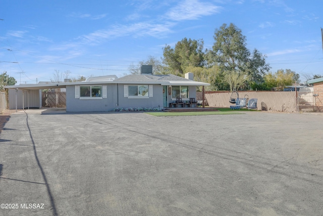 ranch-style home featuring fence, an attached carport, concrete driveway, and stucco siding