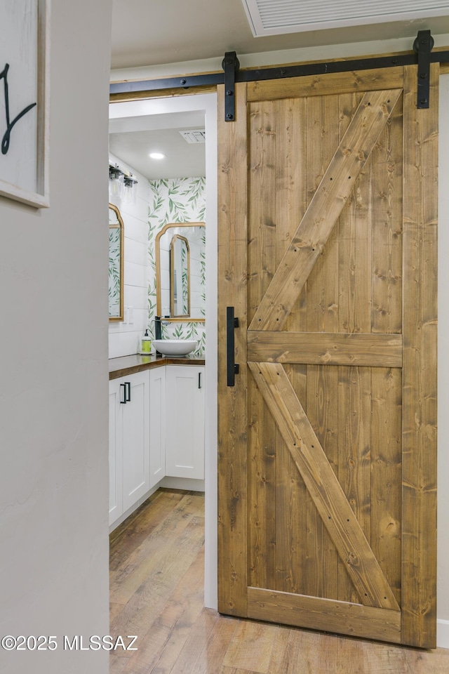 bathroom with visible vents, wood finished floors, and vanity