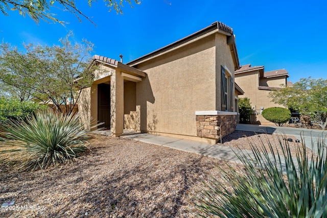 view of home's exterior featuring stone siding and stucco siding