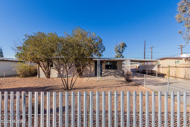 view of front of house featuring fence, an attached carport, and concrete driveway