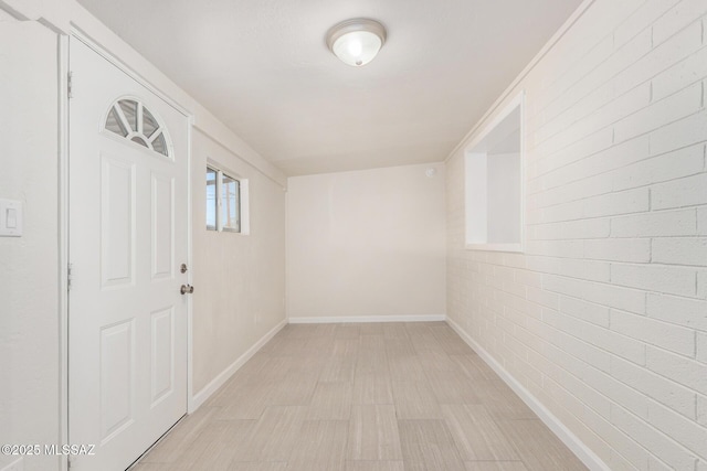 interior space with brick wall and baseboards