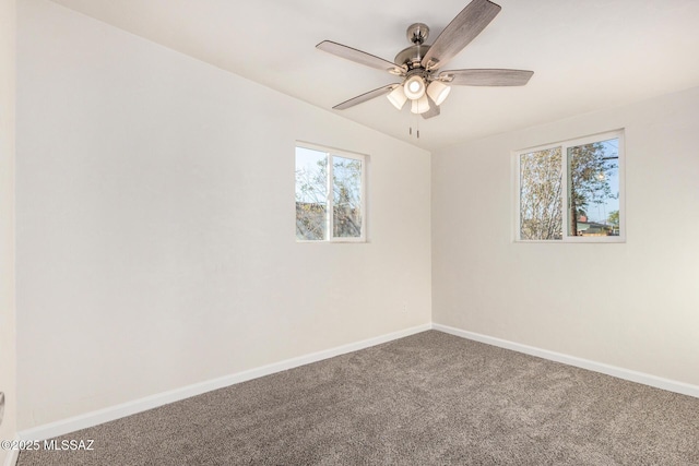 carpeted spare room featuring a ceiling fan and baseboards