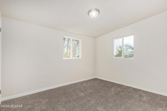 carpeted empty room featuring baseboards