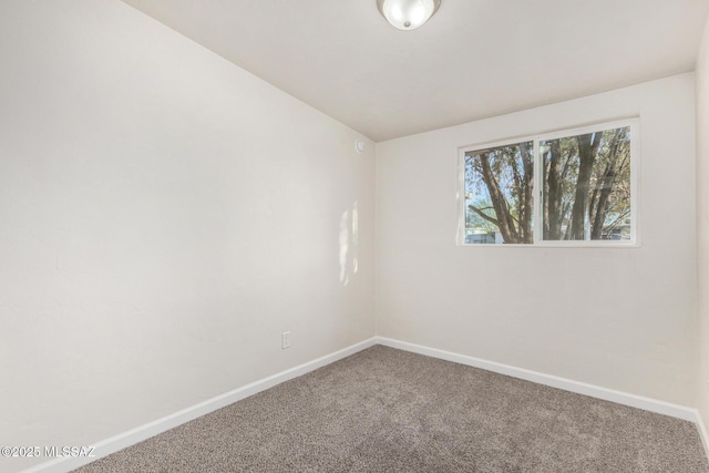 unfurnished room featuring carpet floors and baseboards