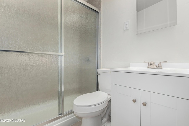 full bathroom with a stall shower, vanity, and toilet