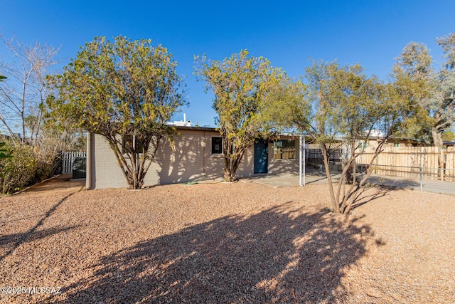 back of property featuring a patio area and fence