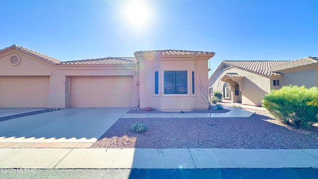 mediterranean / spanish-style home featuring a garage, driveway, a tiled roof, and stucco siding