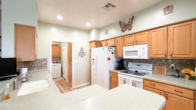 kitchen featuring white appliances, a sink, visible vents, light countertops, and backsplash