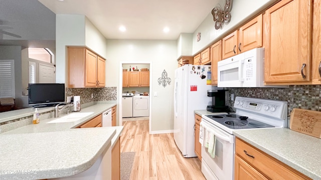 kitchen with light wood-style flooring, light brown cabinetry, a sink, white appliances, and independent washer and dryer