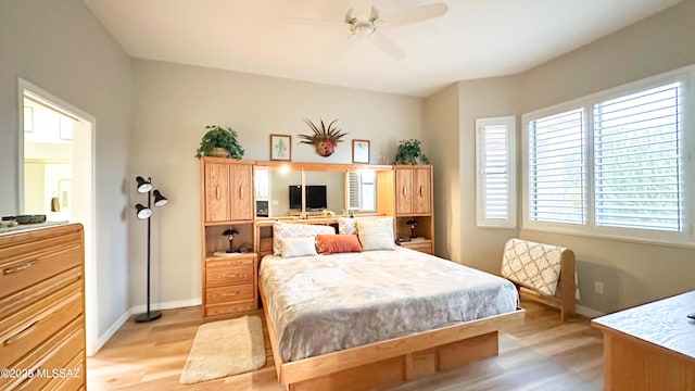 bedroom with light wood-style flooring, baseboards, and a ceiling fan