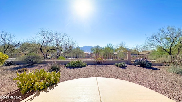 view of yard featuring a patio area, fence, and a mountain view