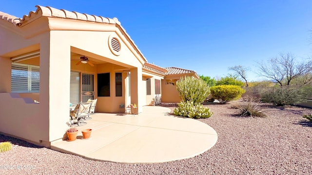 back of property featuring a patio area, ceiling fan, a tiled roof, and stucco siding