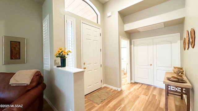 foyer entrance with light wood-style flooring and baseboards