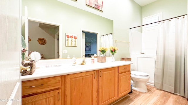 full bath with a shower with shower curtain, vanity, toilet, and wood finished floors