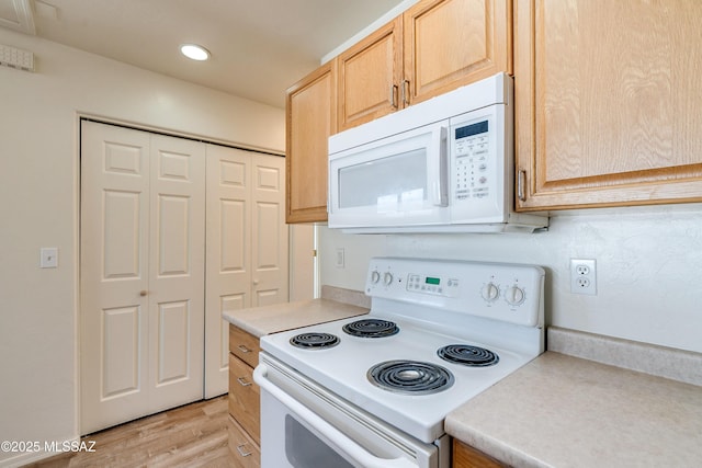 kitchen with light wood-type flooring, white appliances, light countertops, and light brown cabinetry