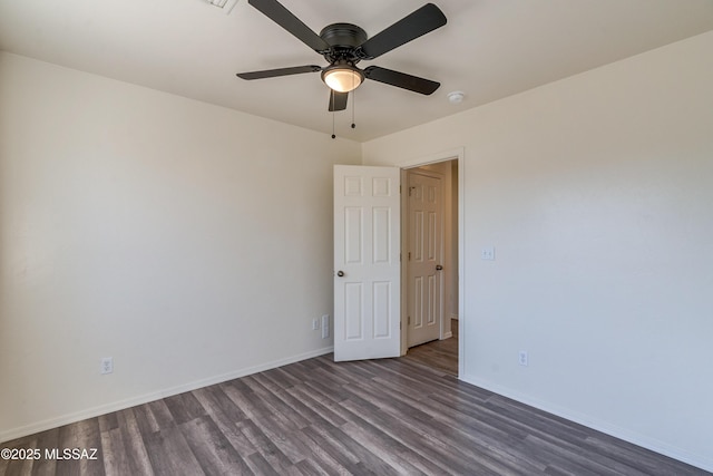 spare room with wood finished floors, a ceiling fan, and baseboards