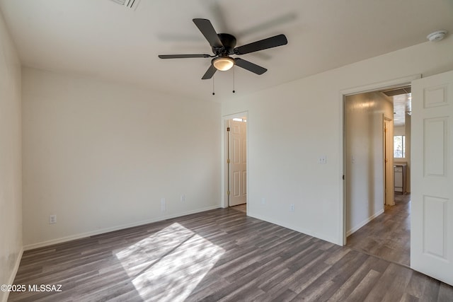 spare room featuring wood finished floors, a ceiling fan, and baseboards