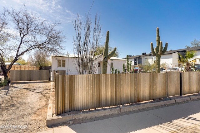 view of front of property featuring fence, a residential view, and stucco siding