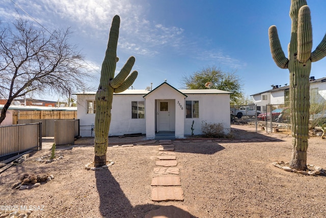 back of house featuring fence and stucco siding