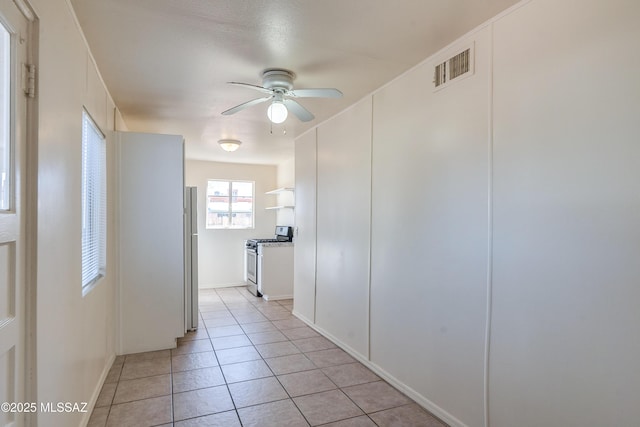 corridor featuring light tile patterned floors and visible vents