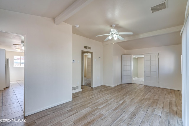 empty room featuring visible vents and vaulted ceiling with beams