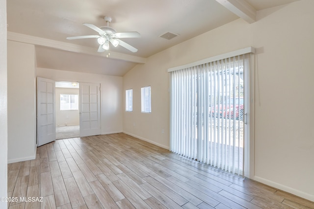 spare room with vaulted ceiling with beams, visible vents, light wood-style flooring, a ceiling fan, and baseboards