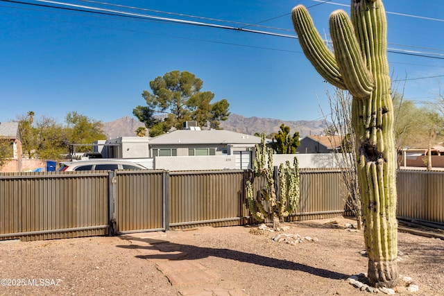 view of yard featuring a gate, fence, and a mountain view