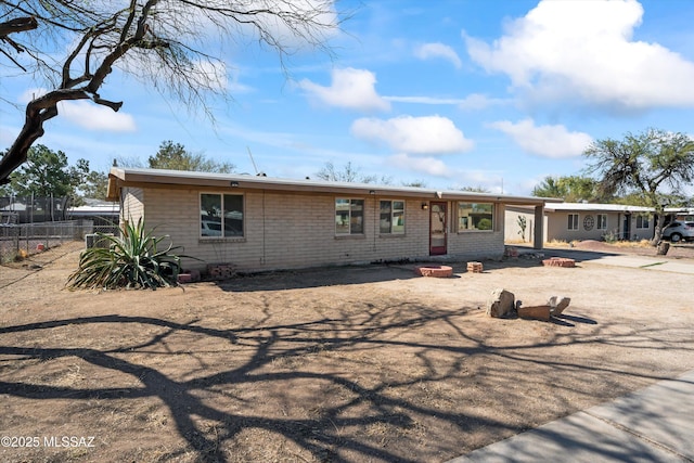 ranch-style house featuring brick siding and fence