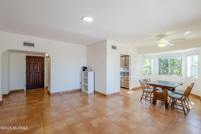 dining room featuring arched walkways, visible vents, and baseboards