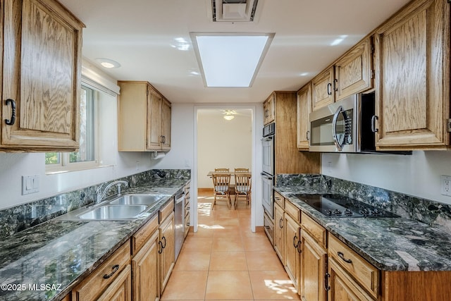 kitchen with light tile patterned floors, stainless steel appliances, a sink, visible vents, and dark stone counters