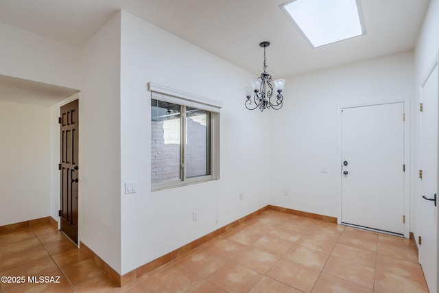 unfurnished dining area featuring light tile patterned floors, a skylight, a chandelier, and baseboards