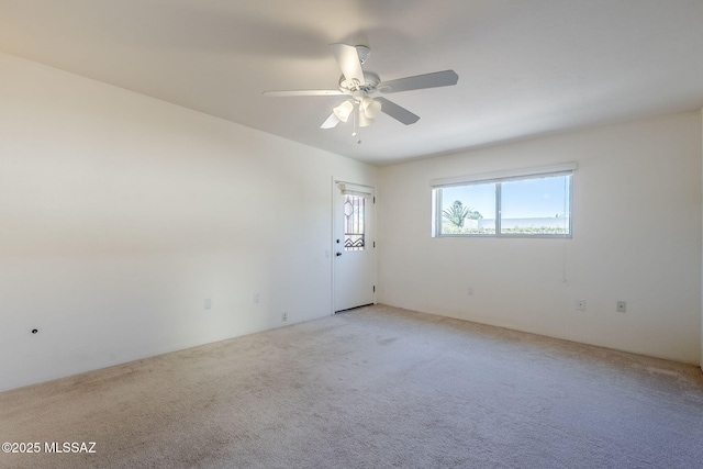 spare room featuring light colored carpet and ceiling fan