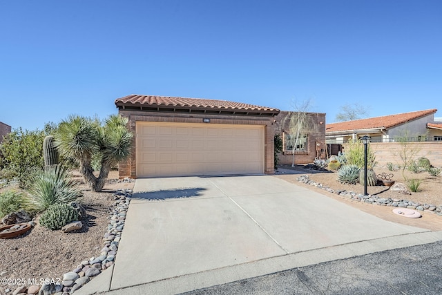 mediterranean / spanish-style home featuring a garage, driveway, a tiled roof, and fence