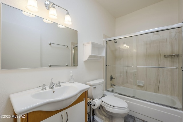 bathroom featuring toilet, bath / shower combo with glass door, and vanity