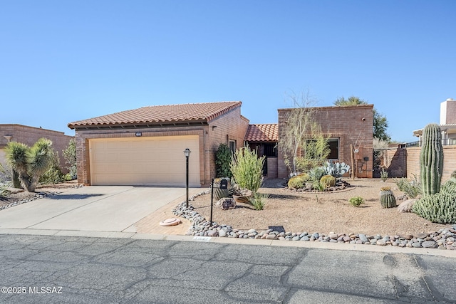 view of front of house with concrete driveway, fence, a tiled roof, and an attached garage