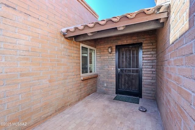 entrance to property featuring brick siding