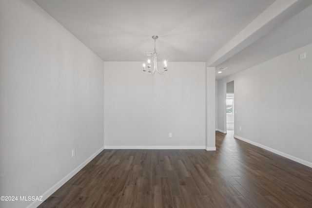 unfurnished room featuring a chandelier, dark wood-style flooring, and baseboards