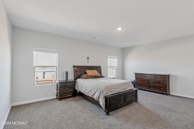 carpeted bedroom featuring baseboards, multiple windows, and visible vents