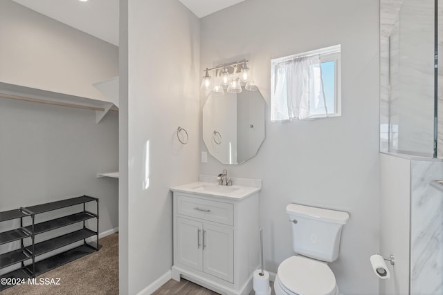 bathroom with vanity, toilet, and baseboards