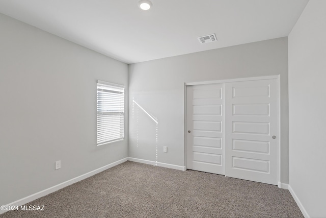 unfurnished bedroom featuring carpet, a closet, visible vents, and baseboards