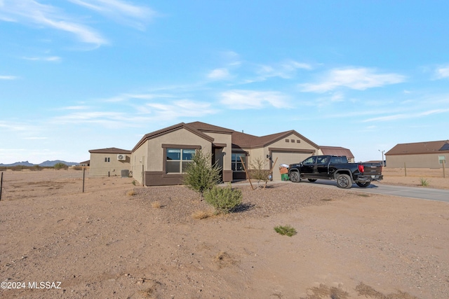 ranch-style home featuring an attached garage, concrete driveway, and stucco siding