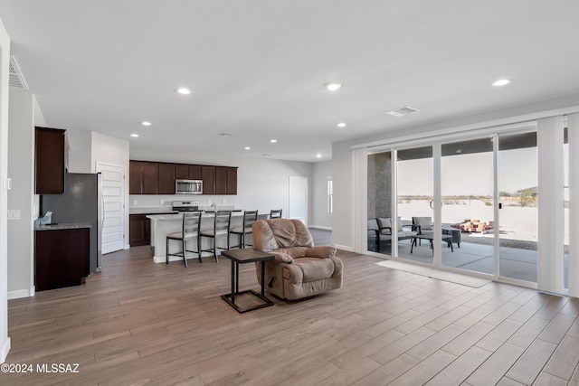 living room featuring light wood-style floors, recessed lighting, and visible vents