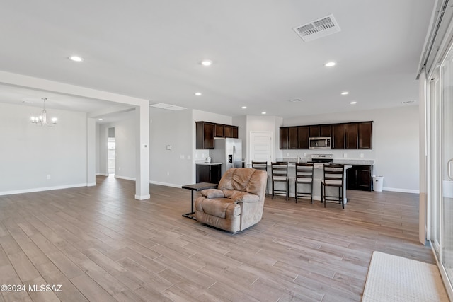 living area featuring baseboards, recessed lighting, visible vents, and light wood-style floors